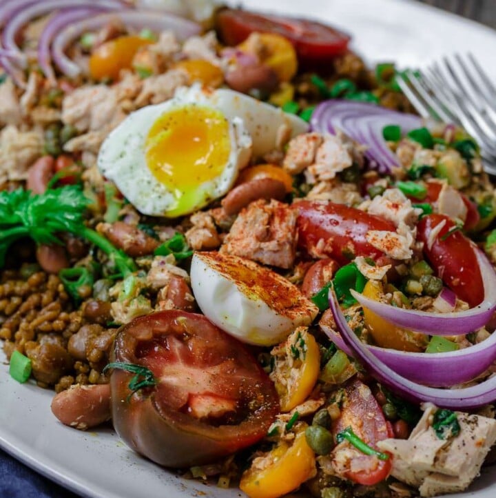 Tuna Couscous Salad Recipe | The Mediterranean Dish. Canned tuna takes on an Italian twist with kindey beans, fresh veggies, capers and more! Add heat and ready couscous pilaf from @wildgardenfoods for an easy weeknight dinner! See the full recipe on TheMediterraneanDish.com