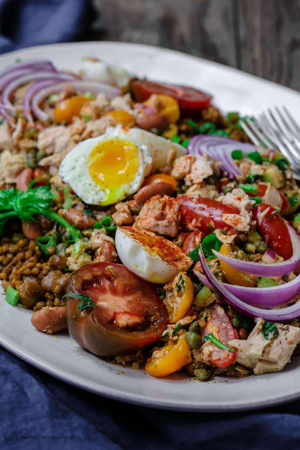 Tuna Couscous Salad Recipe | The Mediterranean Dish. Canned tuna takes on an Italian twist with kindey beans, fresh veggies, capers and more! Add heat and ready couscous pilaf from @wildgardenfoods for an easy weeknight dinner! See the full recipe on TheMediterraneanDish.com