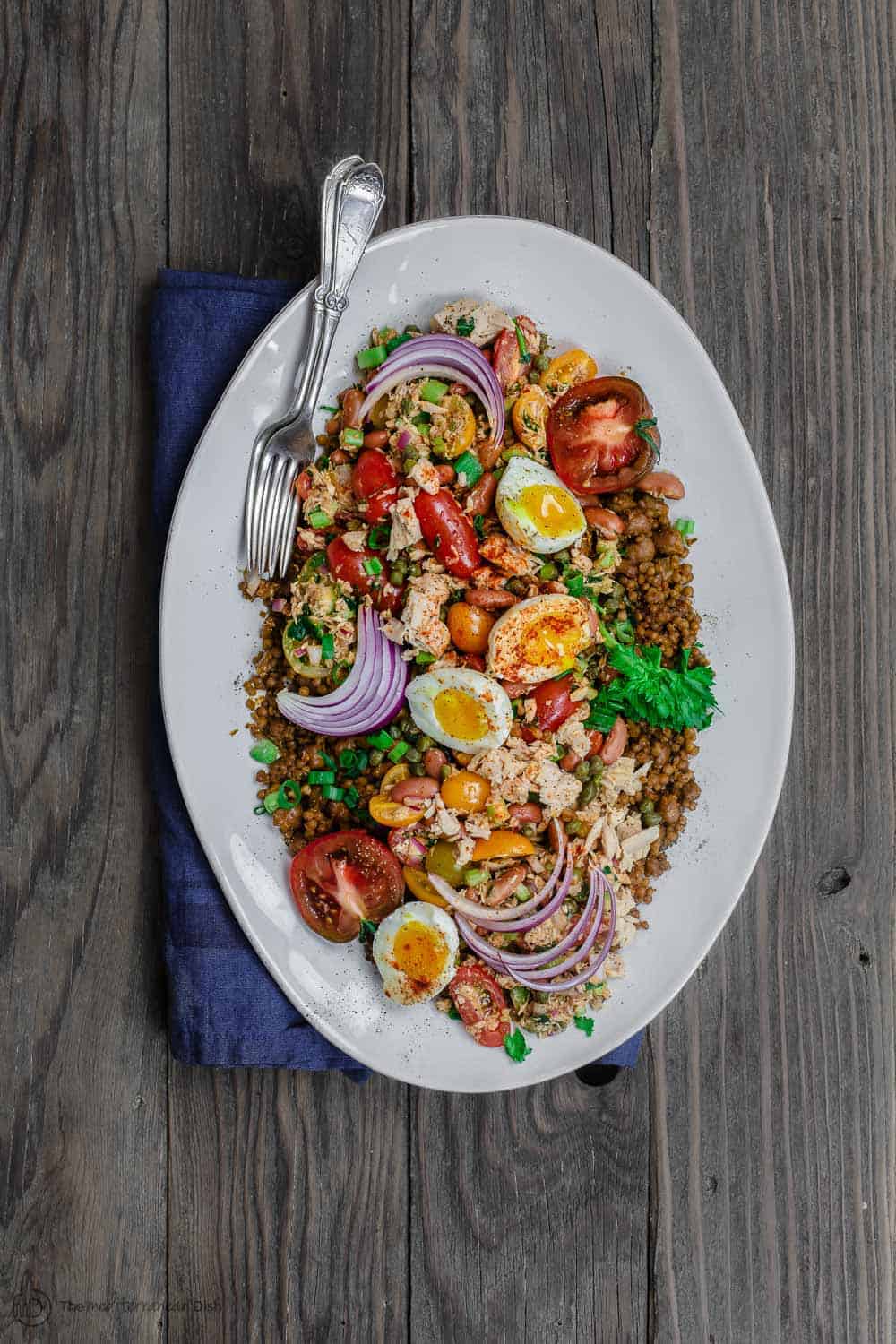 Tuna Couscous Salad Recipe | The Mediterranean Dish. Canned tuna takes on an Italian twist with kindey beans, fresh veggies, capers and more! Add heat and ready couscous pilaf from @wildgardenfoods for an easy weeknight dinner! See the full recipe on TheMediterraneanDish.com