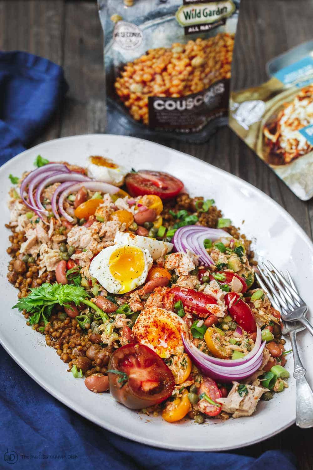 Tuna Couscous Salad Recipe | The Mediterranean Dish. Canned tuna takes on an Italian twist with kindey beans, fresh veggies, capers and more! Add heat and ready couscous pilaf from @wildgardenfoods for an easy weeknight dinner! See the full recipe on TheMediterraneanDish.com