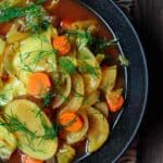 One bowl of cabbage soup, garnished with fresh dill