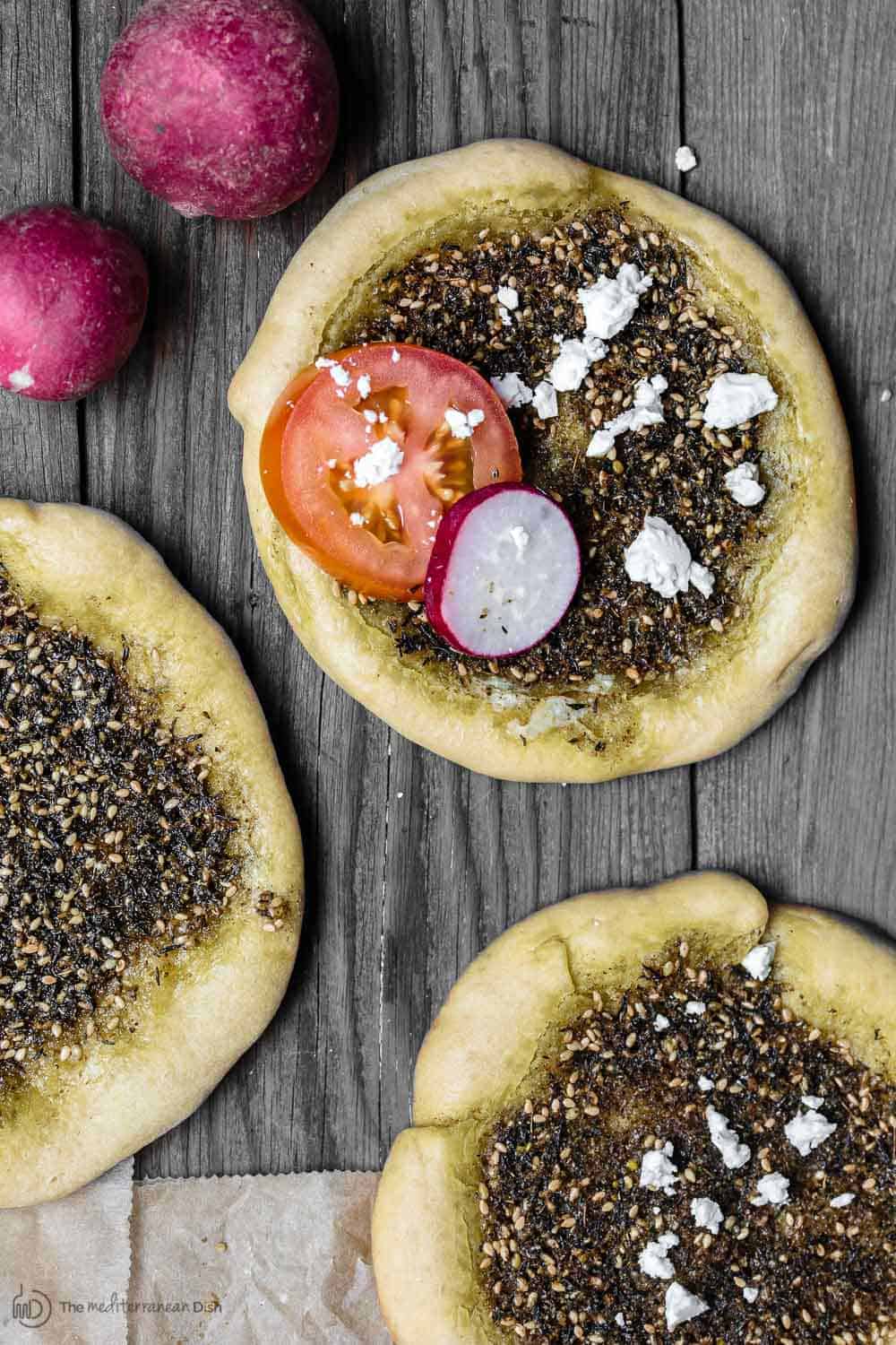 Za'atar Manaqish pastry garnished with cheese, tomato and radish