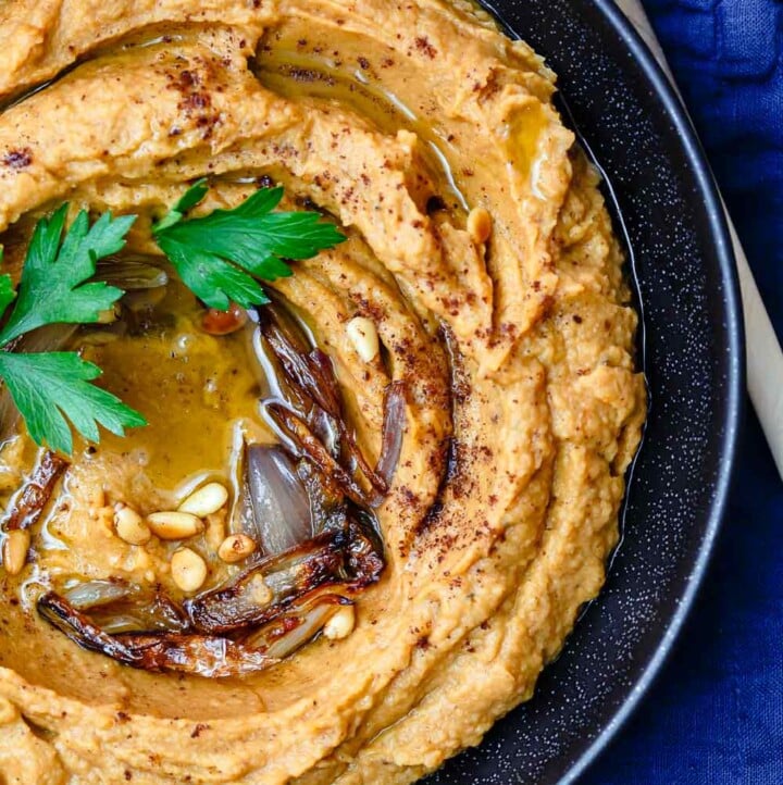 Bean Dip with Roasted Acorn Squash | The Mediterranean Dish. A rustic, flavor-packed white bean dip with a Mediterranean twist. I add caramelized shallots, warm Mediterranean spices, and toasted nuts! See the easy recipe on TheMediterraneanDish.com #beandip #whitebeandip #dip #appetizer #partyfood #holidayrecipe #squash #roastedsquash #hummus #mediterraneanrecipe #mediterraneandiet #mediterraneanfood