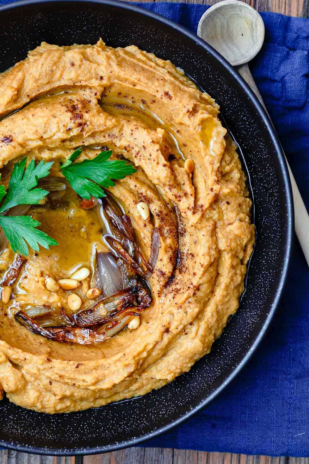 Bean Dip with Roasted Acorn Squash | The Mediterranean Dish. A rustic, flavor-packed white bean dip with a Mediterranean twist. I add caramelized shallots, warm Mediterranean spices, and toasted nuts! See the easy recipe on TheMediterraneanDish.com #beandip #whitebeandip #dip #appetizer #partyfood #holidayrecipe #squash #roastedsquash #hummus #mediterraneanrecipe #mediterraneandiet #mediterraneanfood