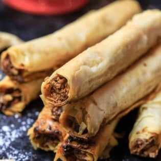 Cashew Filled Baklava Rolls | The Mediterranean Dish. A unique and simple Baklava recipe perfect for entertaining. Perfectly crispy phyllo rolls filled with a tasty cashew mixture and drenched in a lemon simple syrup. See the easy step-by-step tutorial and recipe on TheMediterraneanDish.com #baklava #dessert #pastry #phyllo #baklavarecipe #phyllorecipe #fillo #greekrecipe #turkishrecipe #holidaydessert #fingerfood #partyfood #thanksgiving #christmasdessert #christmas #christmasdinner #christmasbrunch