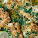 Baked cod in lemon and garlic sauce, garnished with parsley