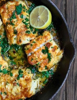 Baked cod recipe with lemon and garlic, served on a cast-iron skillet