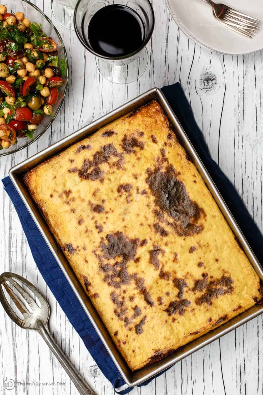 Greek lasagna served with a side of balela salad