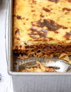 Piece of Greek lasagna cut out of the baking dish