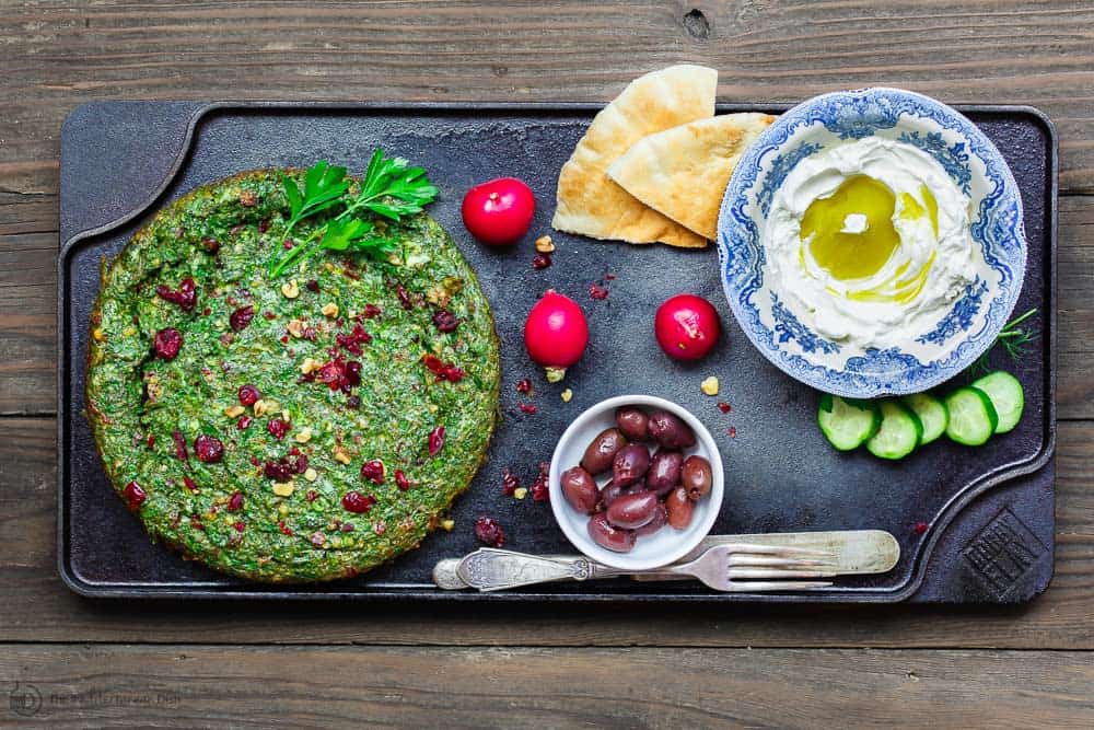 Kuku Sabzi: Persian Herb Baked Omelet | The Mediterranean Dish. Light, herby, flavor-packed Persian baked omelet or frittata with tons of fresh herbs and beautiful spices that will have you coming for more. Perfect for your next special brunch! Get the full recipe on TheMediterraneanDish.com #eggs #breakfast #christmasbrunch #bakedomelet #frittata #mediterraneanrecipe #persianrecipe #kukusabzi 