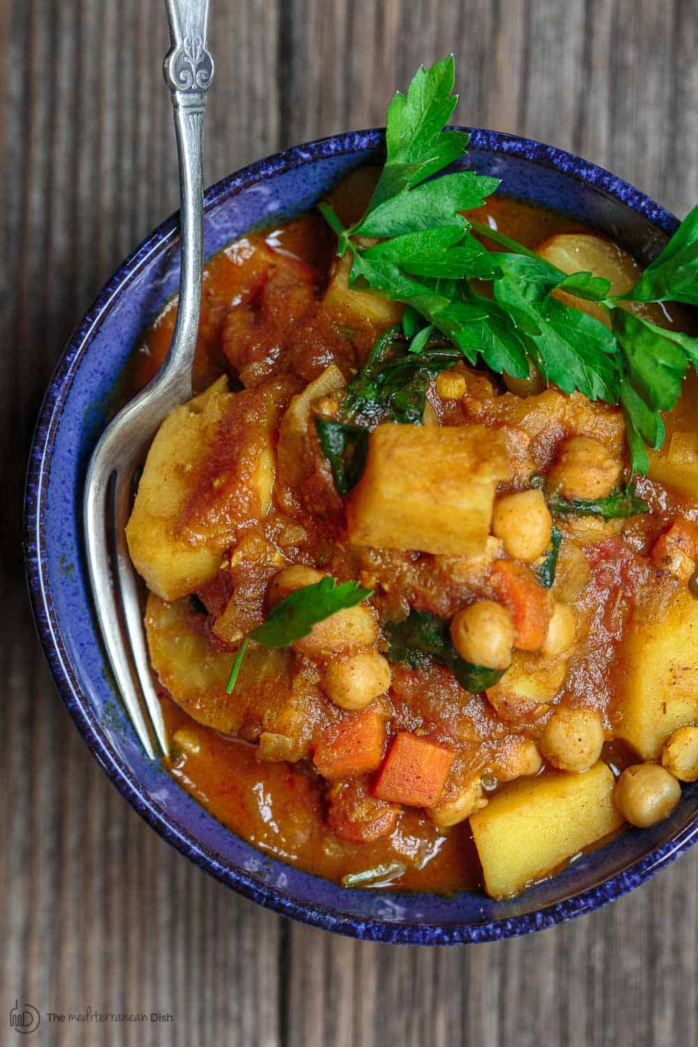 Moroccan Vegetable Tagine Recipe | The Mediterranean Dish. A simple and succulent vegetable stew, flavored Morrocan-style with warm spices, aromatics, and dried apricots. The best vegetable tagine or vegetable stew you'll have. See it on TheMediterraneanDish.com #vegetablestew #tagine #mediterraneanfood #moroccanfood #veganrecipe #onepot