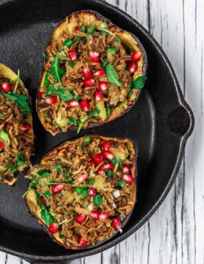 Mediterranean Style Stuffed Acorn Squash Recipe | The Mediterranean Dish.Simple all-start stuffed acorn squash recipe! Prepared Mediterranean-style with an easy rice and lentil pilaf mixture with fresh herbs and pomegranate seeds. A major shortcut makes all the difference! See the recipe on TheMediterraneanDish.com #acornsquash #mediterraneanrecipe #roastedsquash #squashrecipe #thanksigivngdinner