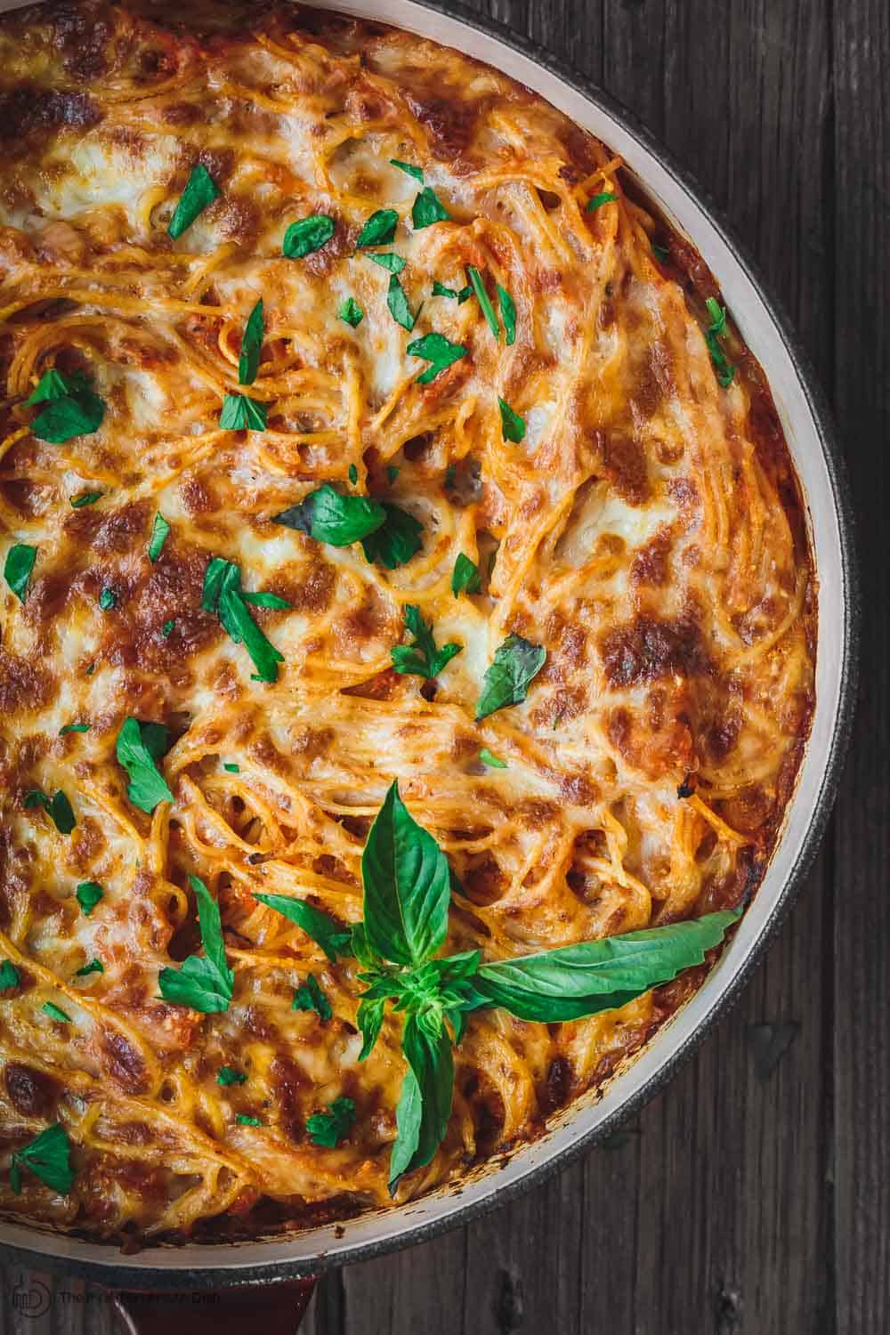 Beautifully browned cheese atop hearty baked spaghetti. Fresh basil and parsley used to garnish.