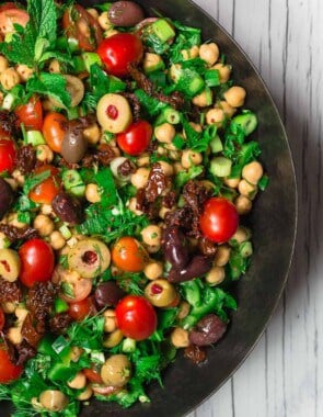 Balela Salad Recipe | The Mediterranean Dish. Bright, flavor-packed Mediterranean chickpea salad with chopped veggies, lots of herbs, and favorites like olives and sun-dried tomatoes. A zesty dressing brings it all together! A simple recipe from TheMediterraneanDish.com #balela #chickpeasalad #mediterraneanfood #mediterraneanrecipe