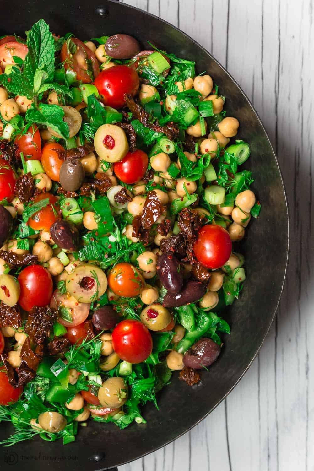 Balela Salad Recipe | The Mediterranean Dish. Bright, flavor-packed Mediterranean chickpea salad with chopped veggies, lots of herbs, and favorites like olives and sun-dried tomatoes. A zesty dressing brings it all together! A simple recipe from TheMediterraneanDish.com #balela #chickpeasalad #mediterraneanfood #mediterraneanrecipe