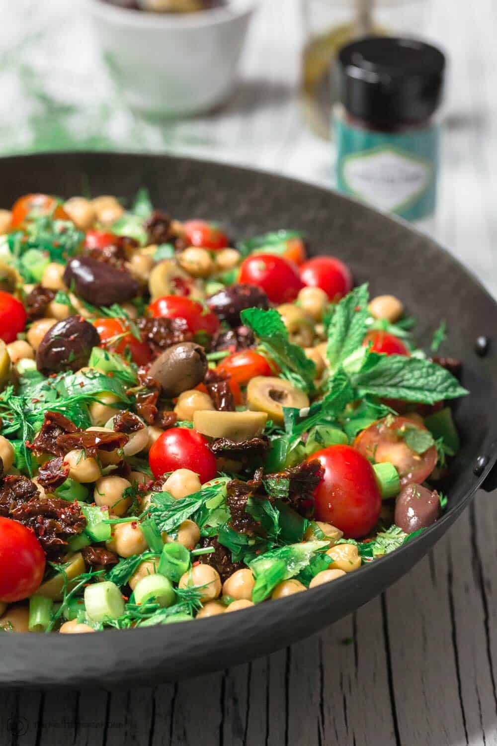 Balela Salad Recipe | The Mediterranean Dish. Bright, flavor-packed Mediterranean chickpea salad with chopped veggies, lots of herbs, and favorites like olives and sun-dried tomatoes. A zesty dressing brings it all together! A simple recipe from TheMediterraneanDish.com #balela #chickpeasalad #mediterraneanfood #mediterraneanrecipe