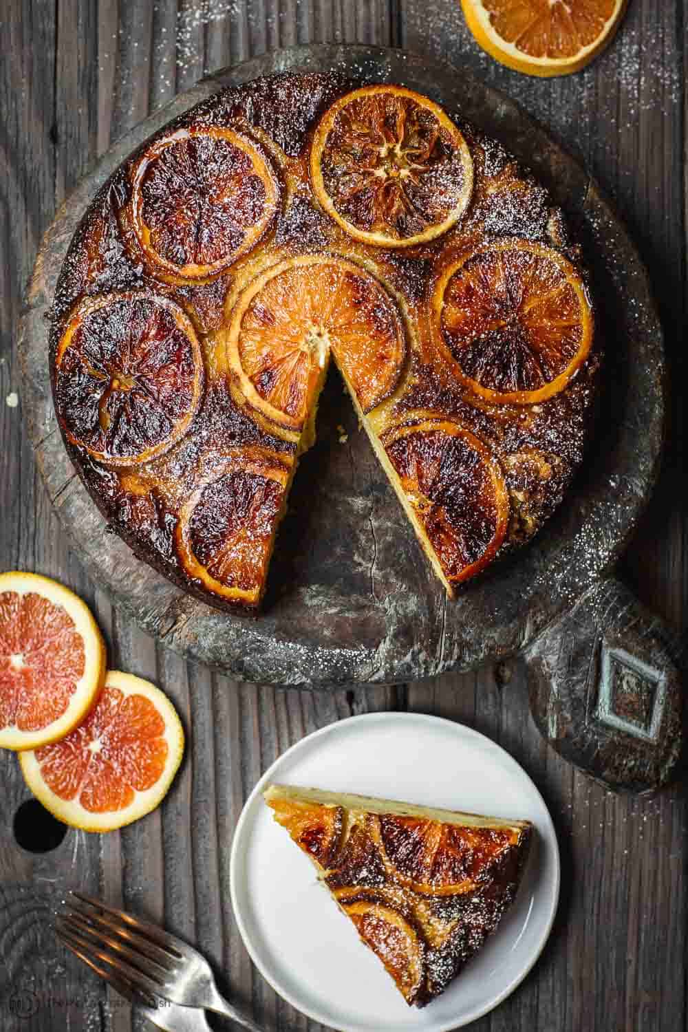 One slice of Orange Ricotta Cake served on plate. Cake platter to the side