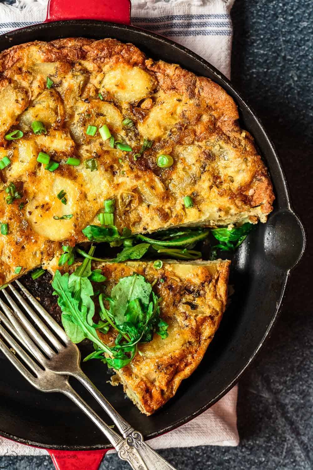 Simple Spanish Tortilla Sliced to Serve. Topped with Arugula Salad