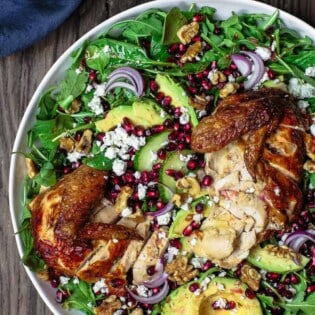 Chicken Arugula Salad with Ginger Pomegranate Dressing | The Mediterranean Dish. Loaded arugula salad with pomegranates, avocado, cucumber, and chicken. The best fresh ginger and pomegranate dressing brings so much flavor and brightness. Simple weeknight dinner! From TheMediterraneanDish.com #arugulasalad #mediterraneandiet #mediterraneanrecipes #mediterraneanfood #healthyrecipes #salad #healthydinner #lowcaloriedinner