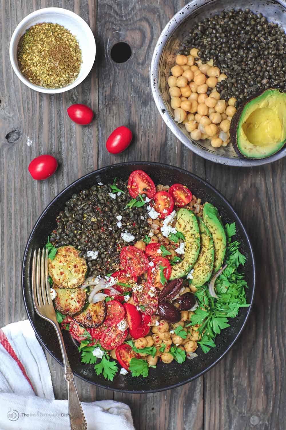 Mediterranean Grain Bowls with lentils, zucchini, avocados, tomatoes and topped with feta cheese.