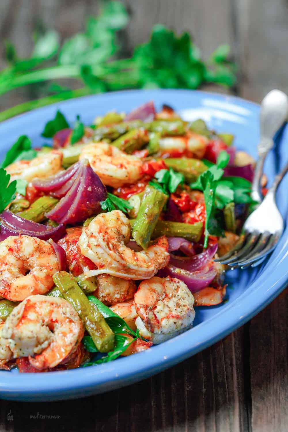 Baked shrimp with Mediterranean flavors and healthy veggies served on a dish