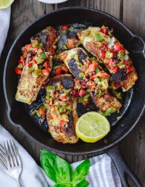 Mediterranean Pan Seared Sea Bass Recipe | The Mediterranean Dish. Quick and crispy pan seared sea bass, coated with Mediterranean spices and a tasty bell pepper medley to serve on top or as a side! Dinner in minutes! from TheMediterraneanDish.com #mediterraneandiet #mediterraneanrecipes #seafoodrecipes #fish #fishrecipes #healthyrecipes #lowcarbrecipes #weeknightdinner #weeknightmeal #onpotdinner #onepan #glutenfreerecipes #seabass #easyrecipes