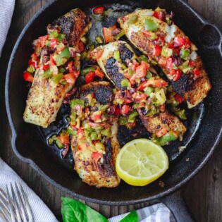 Mediterranean Pan Seared Sea Bass Recipe | The Mediterranean Dish. Quick and crispy pan seared sea bass, coated with Mediterranean spices and a tasty bell pepper medley to serve on top or as a side! Dinner in minutes! from TheMediterraneanDish.com #mediterraneandiet #mediterraneanrecipes #seafoodrecipes #fish #fishrecipes #healthyrecipes #lowcarbrecipes #weeknightdinner #weeknightmeal #onpotdinner #onepan #glutenfreerecipes #seabass #easyrecipes