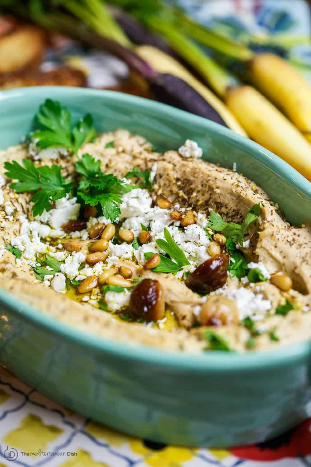 Roasted Garlic Hummus | The Mediterranean Dish. Smooth and creamy hummus dip with the perfect flavor combination. Sweet. Smoky. And just enough zing. Top it with toasted pine nuts, and feta. The best roasted garlic hummus ever from TheMediterraneanDish.com