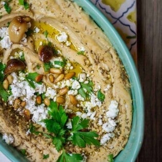 Roasted Garlic Hummus | The Mediterranean Dish. Smooth and creamy hummus dip with the perfect flavor combination. Sweet. Smoky. And just enough zing. Top it with toasted pine nuts, and feta. The best roasted garlic hummus ever from TheMediterraneanDish.com
