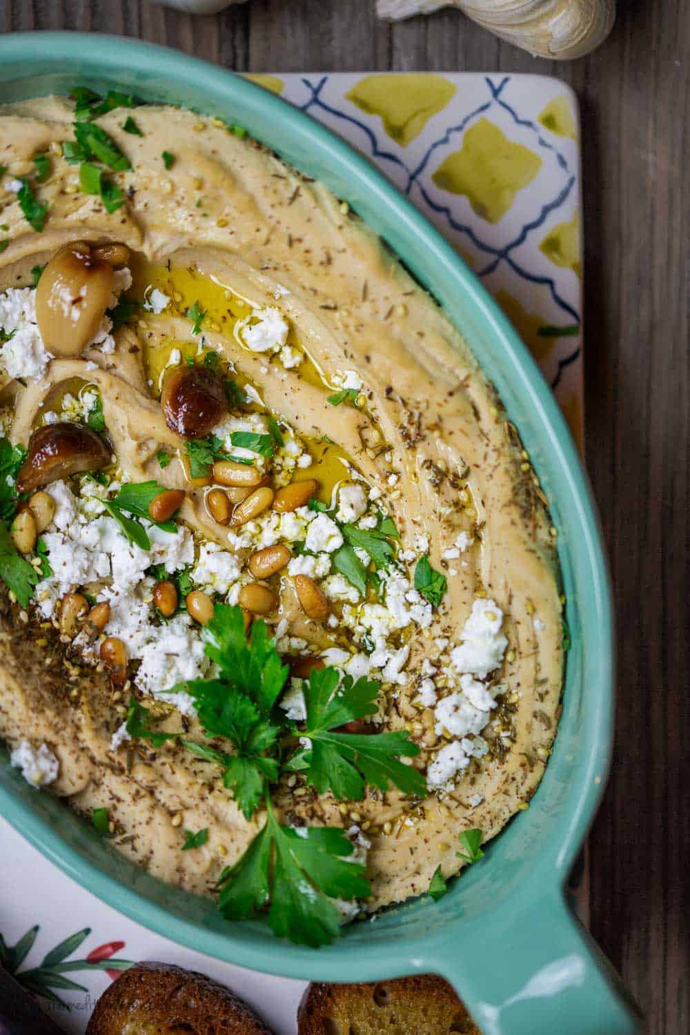 Roasted Garlic Hummus | The Mediterranean Dish. Smooth and creamy hummus dip with the perfect flavor combination. Sweet. Smoky. And just enough zing. Top it with toasted pine nuts, and feta. The best roasted garlic hummus ever from TheMediterraneanDish.com