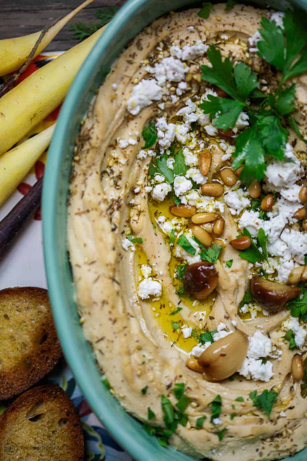 Roasted Garlic Hummus | The Mediterranean Dish. Smooth and creamy hummus dip with the perfect flavor combination. Sweet. Smoky. And just enough zing. Top it with toasted pine nuts, and feta. The best roasted garlic hummus ever from TheMediterraneanDish.com