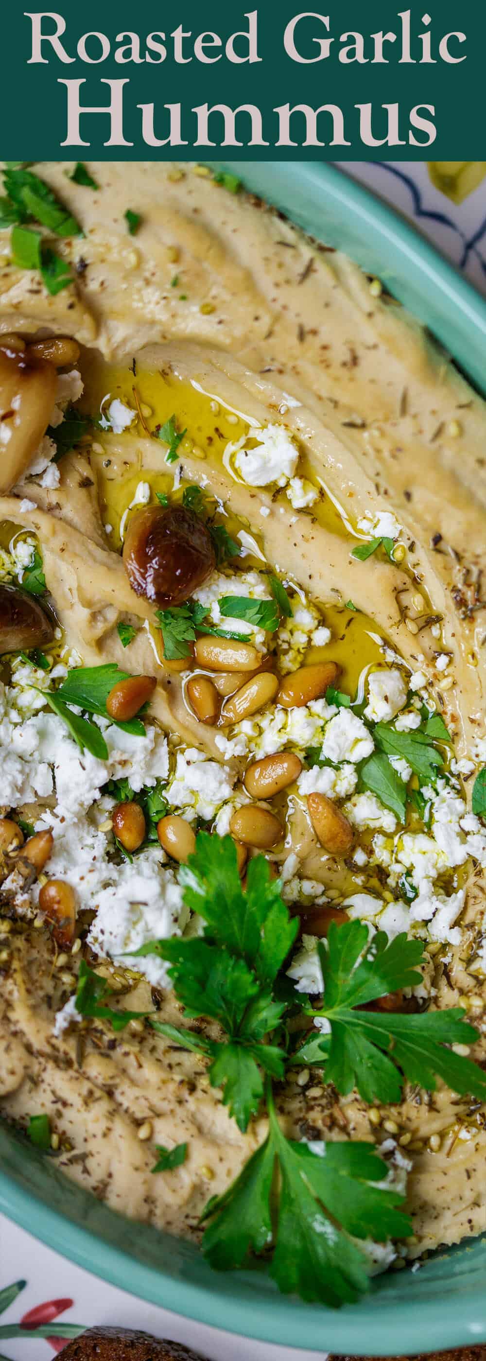 Roasted Garlic Hummus | The Mediterranean Dish. Smooth and creamy hummus dip with the perfect flavor combination. Sweet. Smoky. And just enough zing. Top it with toasted pine nuts, and feta. The best roasted garlic hummus ever from TheMediterraneanDish.com #hummus #hummusdip #mediterraneandiet #mediterraneanrecipes #roastedgarlichummus #chickpeas #dip #glutenfree #vegetarian 