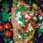 Loaded Mediterranean Omelette Recipe | The Mediterranean Dish. Perfectly-seasoned omelette loaded with fresh herbs and Mediterranean favorites like tomato, artichokes, feta and more. There is a secret ingredient that makes this omelette a little extra airy and fluffly! From TheMediterraneanDish.com