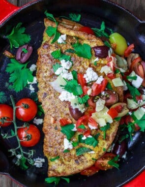 Loaded Mediterranean Omelette Recipe | The Mediterranean Dish. Perfectly-seasoned omelette loaded with fresh herbs and Mediterranean favorites like tomato, artichokes, feta and more. There is a secret ingredient that makes this omelette a little extra airy and fluffly! From TheMediterraneanDish.com