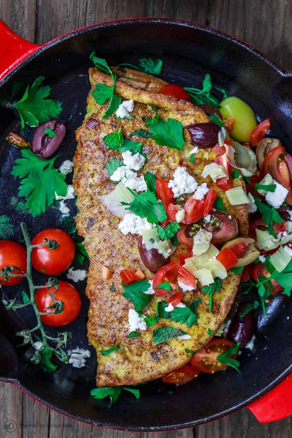 Egg Omelette covered in olives, tomatoes, feta cheese and parsley