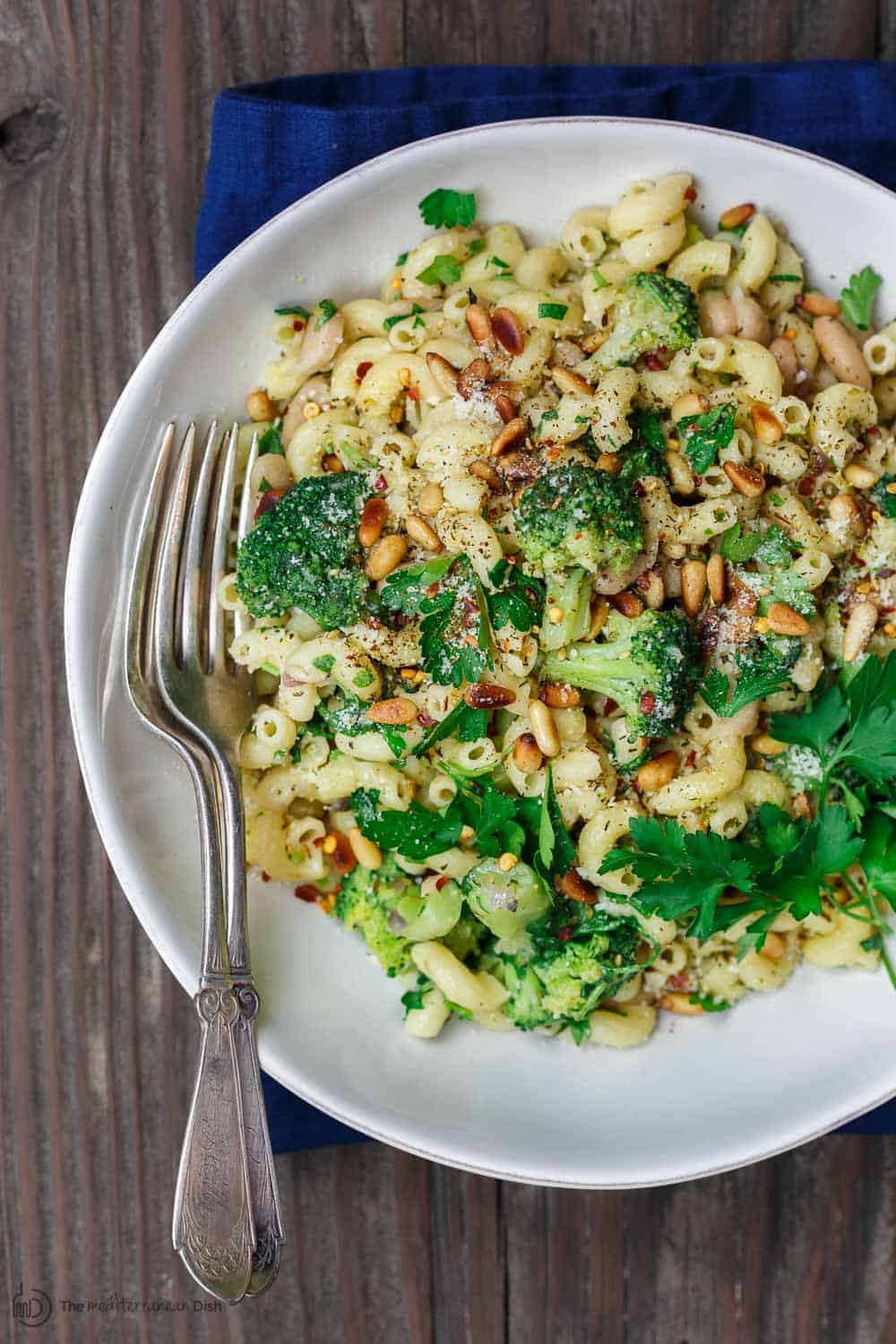 Broccoli pasta, served in a dinner bowl and garnished with grated parmesan and fresh parsley