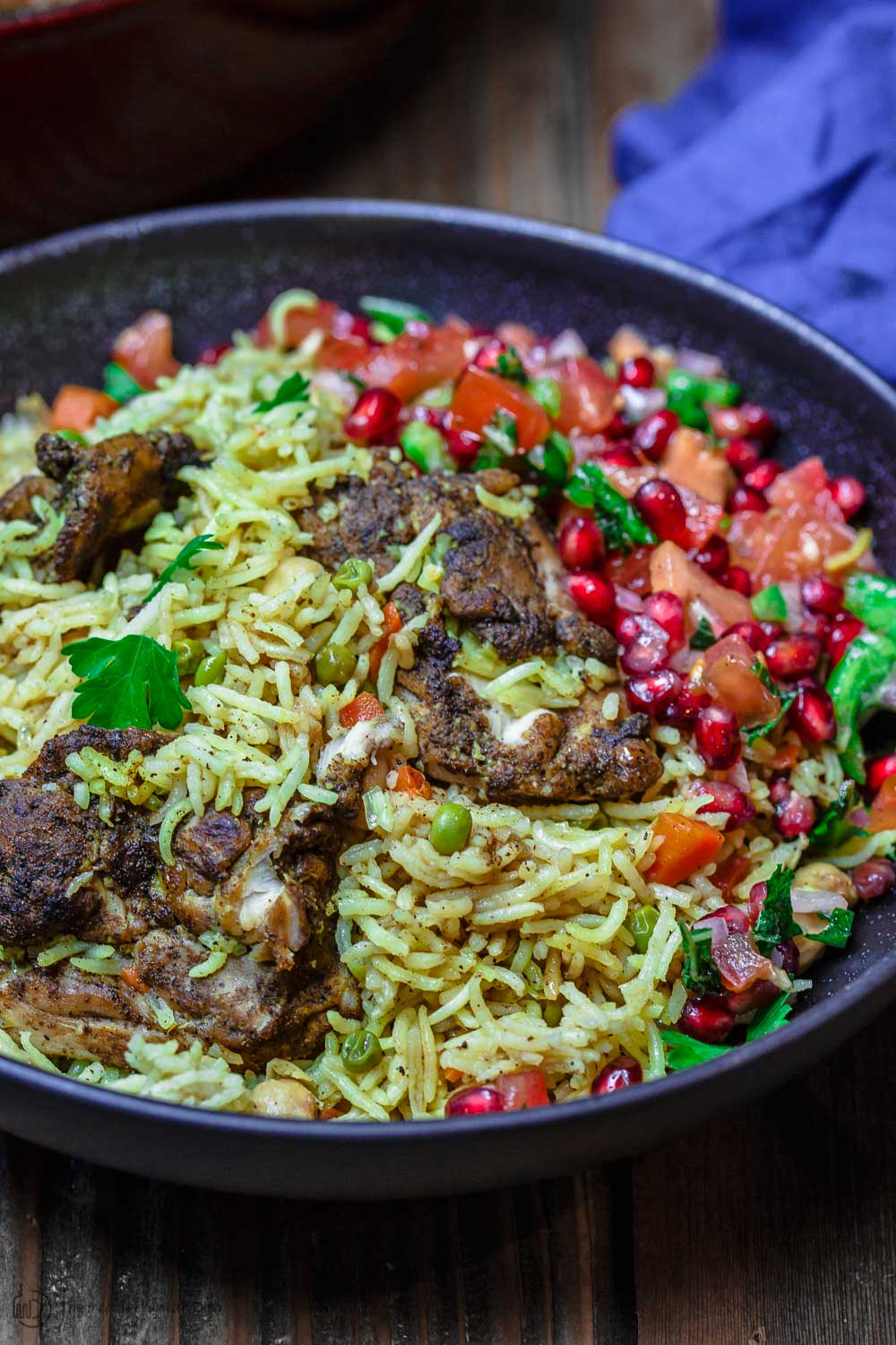 Chicken and rice served in a bowl with a pomegranate salad