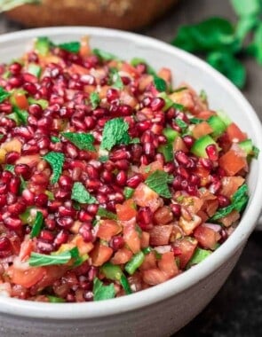 Mediterranean Pomegranate Tomato Salad | The Mediterranean Dish. This Mediterranean salad uses so few ingredients. So bright and flavor-packed! Tangy pomegranates and sunny sweet tomatoes are the perfect combination, with fresh mint and shallots! And the dressing is amazing! From TheMediterraneanDish.com