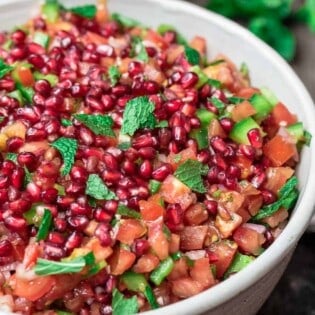 Mediterranean Pomegranate Tomato Salad | The Mediterranean Dish. This Mediterranean salad uses so few ingredients. So bright and flavor-packed! Tangy pomegranates and sunny sweet tomatoes are the perfect combination, with fresh mint and shallots! And the dressing is amazing! From TheMediterraneanDish.com