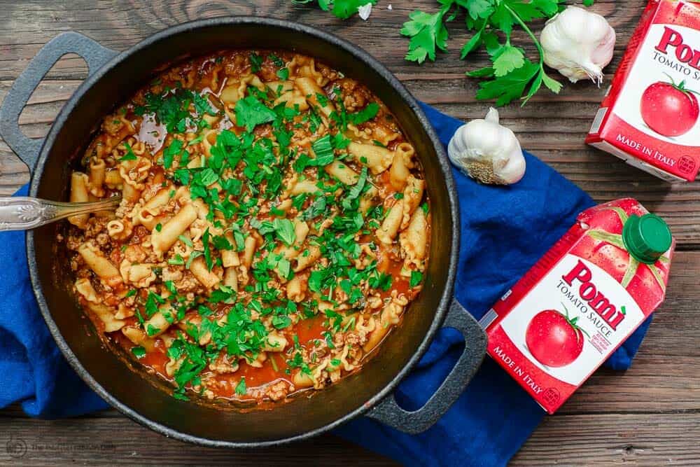 Lasagna soup in cast iron pot, garnished with fresh parsley