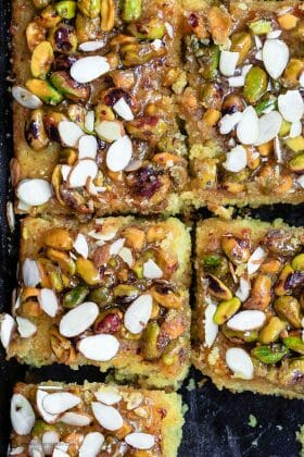 Greek Orange Honey Cake | The Mediterranean Dish. This super simple Greek cake is made with olive oil and Greek yogurt, and perfectly flavored with lots of citrus. Topped with toasted pistachios and a luscious honey syrup. A foolproof honey cake that can feed a crowd! See it on TheMediterraneanDish.com #cake #oliveoilcake #mediterraneandiet #easterdinnerideas #easterdinner #dessertrecipes #chirstmasrecipes #christmasdinnerideas #easterrecipes