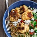 Herbed Couscous Recipe with Roasted Cauliflower | The Mediterranean Dish. Perfectly satisfying dinner bowls with flavor-packed herb couscous, perfectly roasted cauliflower, and an easy Mediterranean salad. Recipe comes with tips for best roasted cauliflower! Omit the feta for vegan dinner bowls. Recipe from TheMediterraneanDish.com