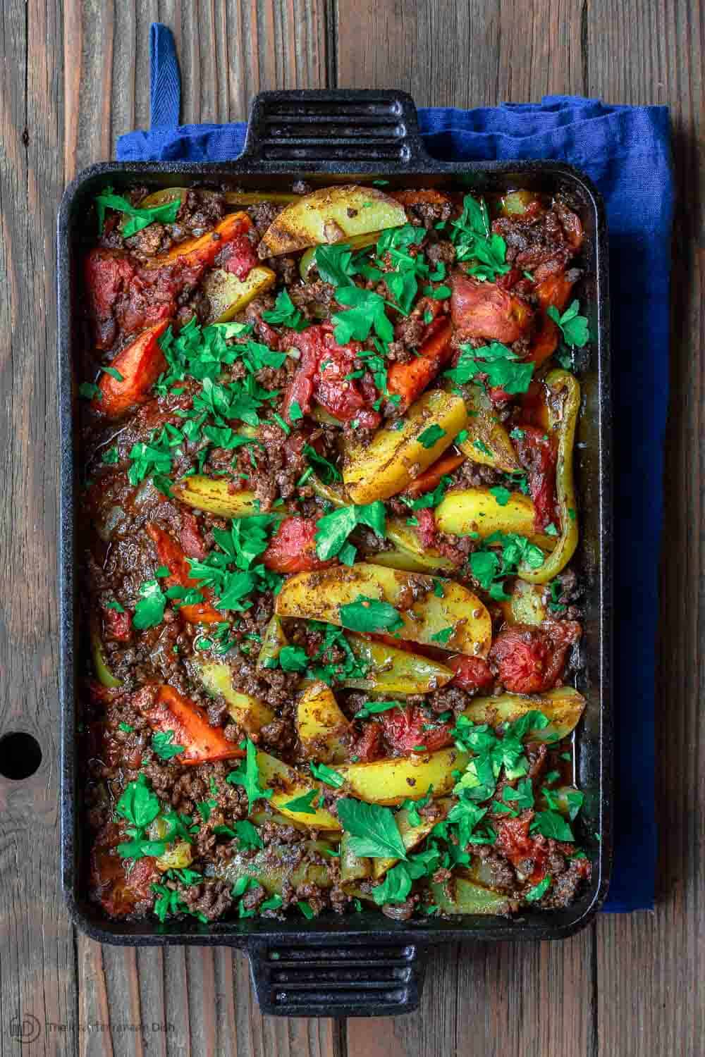 Skillet containing Egyptian Potato Casserole garnished with fresh parsley