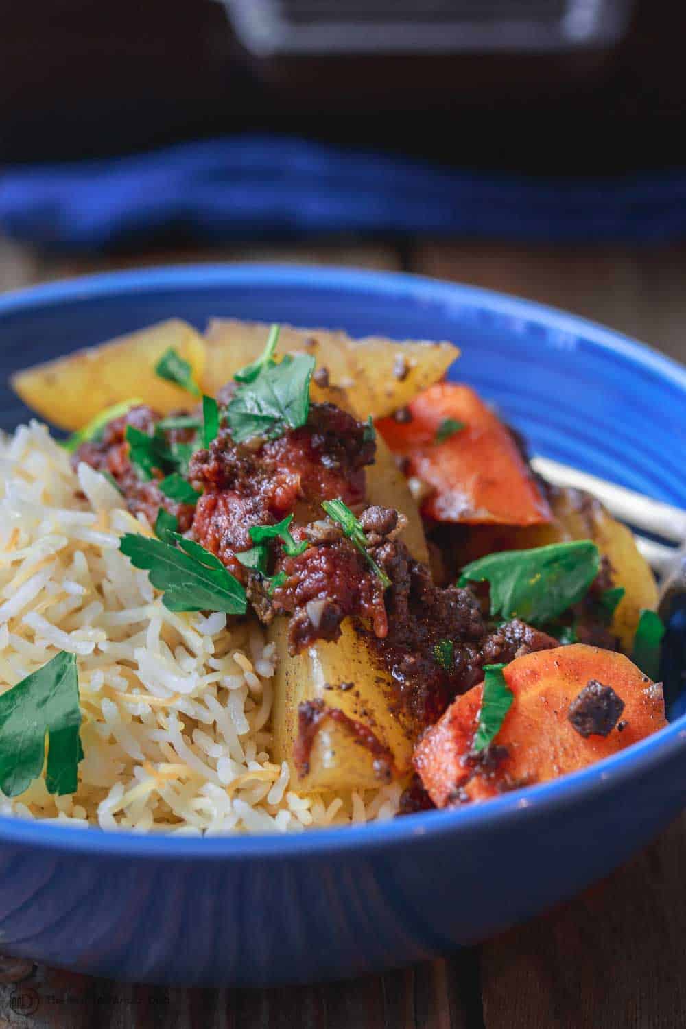 Close-up of Egyptian Potato Casserole served with vegetables and rice