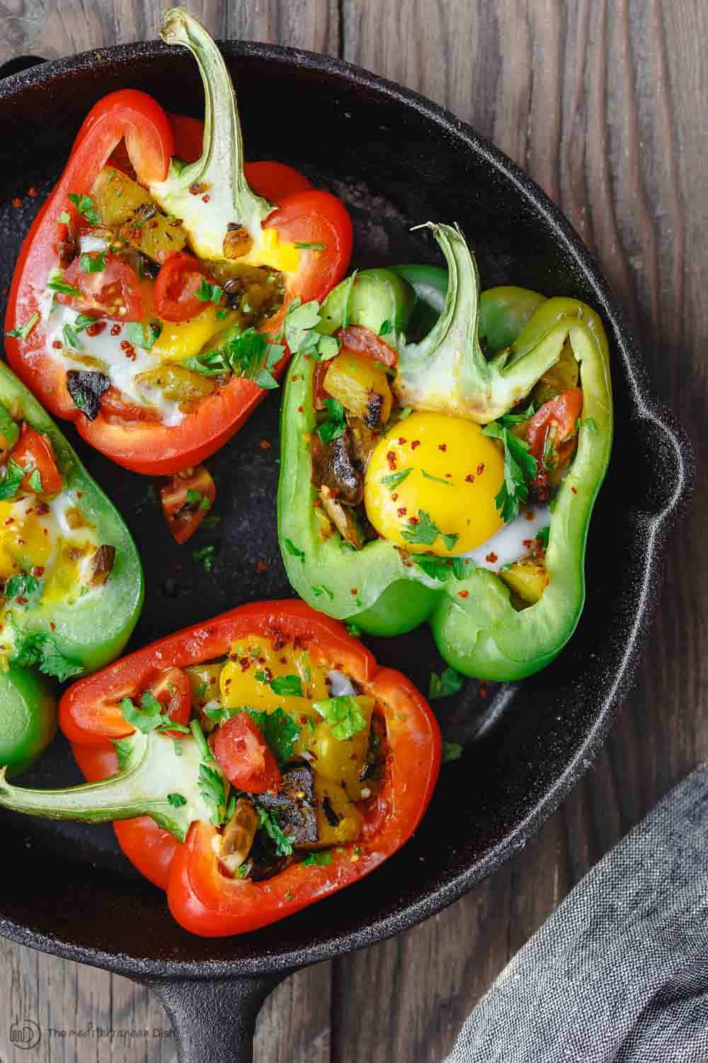 Easy Stuffed Peppers | The Mediterranean Dish. These stuffed peppers are filled with a gluten free and vegetarian potato hash and topped with a perfectly melty egg. Serve them for brunch or dinner, you'll love these healthy stuffed peppers, prepared Mediterranean style. See it on TheMediterraneanDish.com #stuffedpeppers #mediterraneandiet #breakfast #brunch #potatoes #potatohash #glutenfree #breakfasthash #easyrecipes #bellpeppers #healthyrecipe #vegetarian #mothersdaybrunch