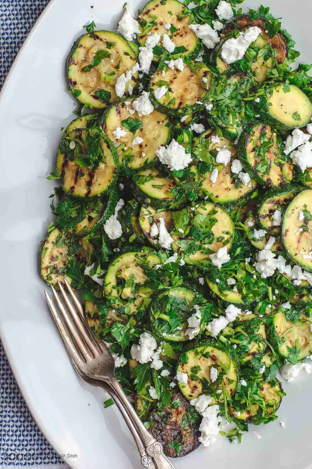 Mediterranean Style Grilled Zucchini Salad | The Mediterranean Dish. Simple, flavor-packed grilled zucchini with fresh herbs and other Mediterranean favorites. Ready in 15 minutes. Recipe from TheMediterraneanDish.com