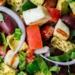 Simple Mediterranean Avocado Salad | The Mediterranean Dish. The BEST avocado salad, prepared Mediterranean style with tomatoes, cucumbers and a the perfect garlic vinaigrette! Use grilled halloumi cheese for croutons, or leave them out for a vegan option. #avocado #avocadosalad #mediterraneandiet #mediterraneanfood #salad #avocados #vegetarianrecipes #glutenfree