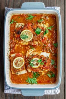 Mediterranean Baked Fish Recipe with Tomatoes and Capers | The Mediterranean Dish. Easy, bright, flavor-packed baked fish, prepared Mediterranean style with spices, tomatoes and capers. From TheMediterraneanDish.com #healthyrecipes #fishrecipe #bakedfish #cod #halibut #glutenfree #seafoodrecipe #seafood #fish #mediterraneandiet #mediterranean #easyrecipe