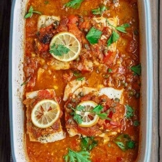 Mediterranean Baked Fish Recipe with Tomatoes and Capers | The Mediterranean Dish. Easy, bright, flavor-packed baked fish, prepared Mediterranean style with spices, tomatoes and capers. From TheMediterraneanDish.com #healthyrecipes #fishrecipe #bakedfish #cod #halibut #glutenfree #seafoodrecipe #seafood #fish #mediterraneandiet #mediterranean #easyrecipe