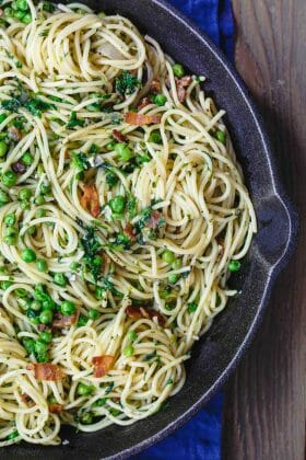 Simple Pasta with Peas and Pancetta | The Mediterranean Dish. Super bright and flavor-packed pasta. Pasta with peas in a light garlic and olive oil sauce. Pancetta or bacon, fresh herbs, and lemon zest add a lot of flavor. Recipe from TheMediterraneanDish.com #pasta #pastarecipe #spaghetti #peas #mediterraneandiet #mediterraneanrecipes #Italian #Italianfood #Italianrecipes #springrecipe #pastarecipe #oliveoilrecipe